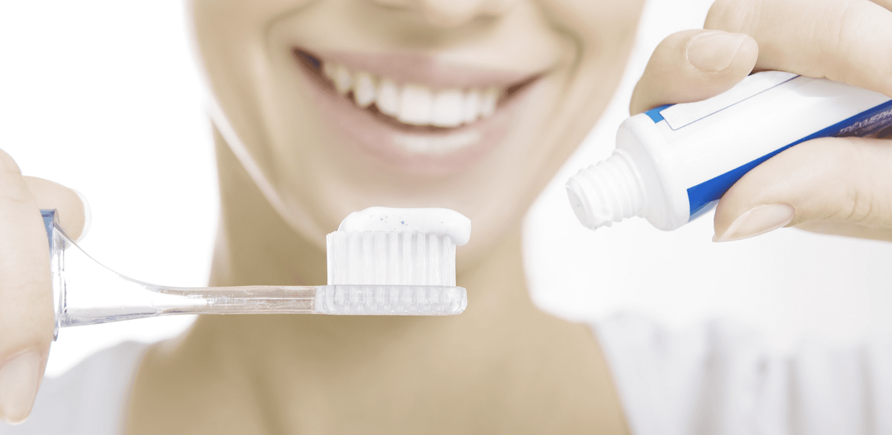 woman holding a toothbrush and a toothpaste