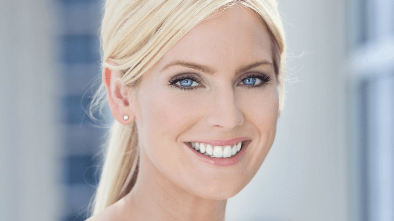 woman with blonde hair and blue eyes smiling